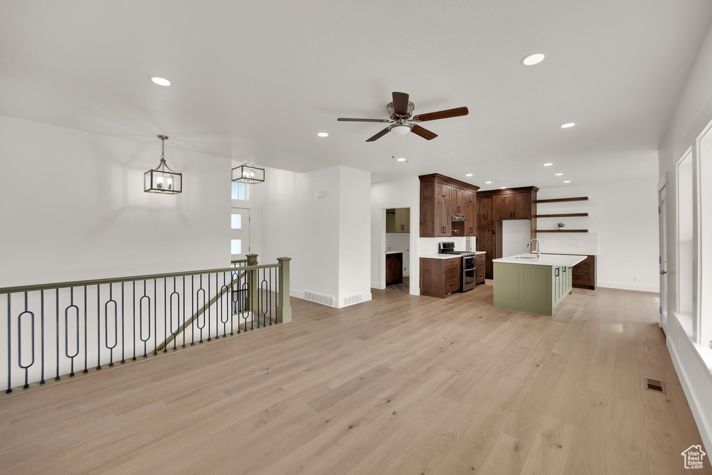Unfurnished living room featuring a ceiling fan, recessed lighting, and light wood finished floors