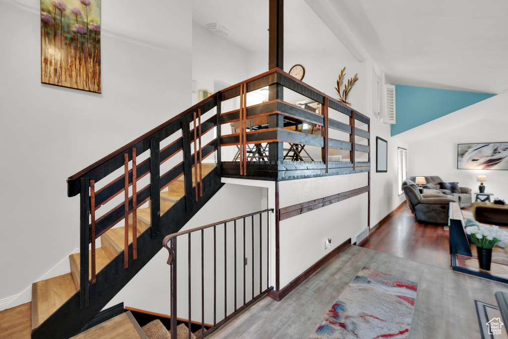 Staircase with wood finished floors and baseboards