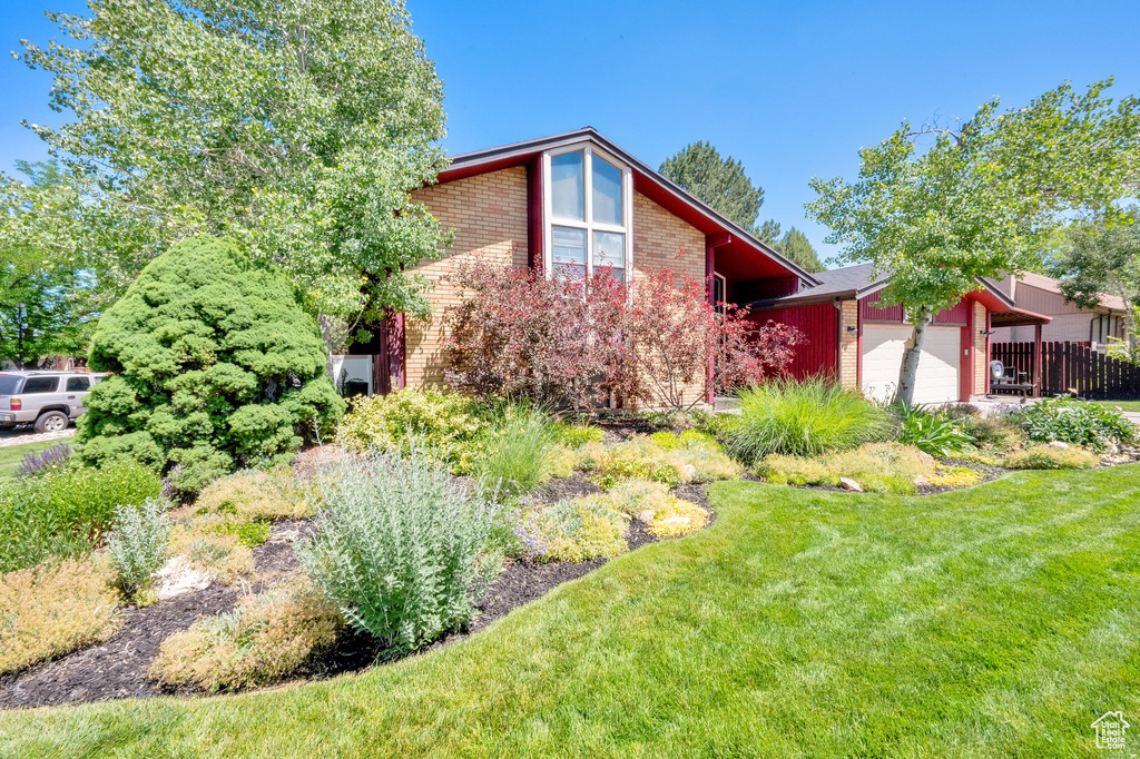View of front of house featuring brick siding and a garage