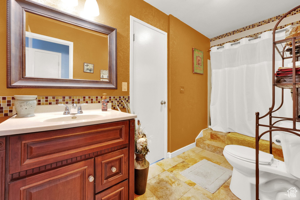 Bathroom featuring tasteful backsplash, vanity, and shower / tub combo