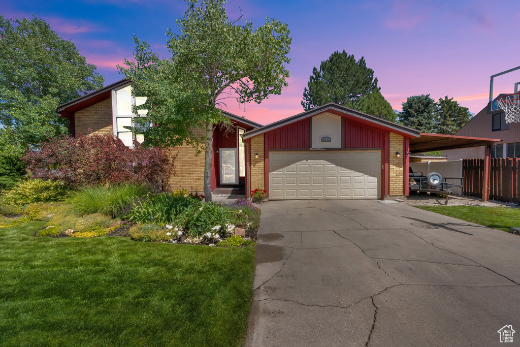 Mid-century home with brick siding, a garage, and concrete driveway