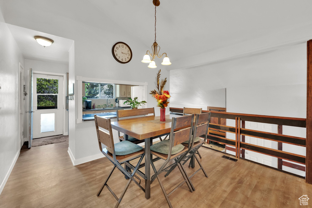 Dining room featuring light wood finished floors and a chandelier