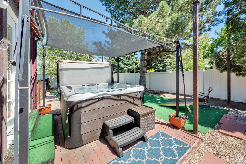 Fenced backyard featuring a hot tub