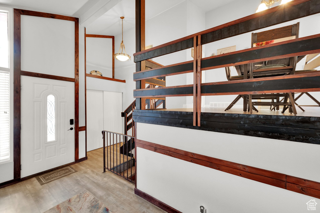 Entryway featuring light wood-style floors and a towering ceiling