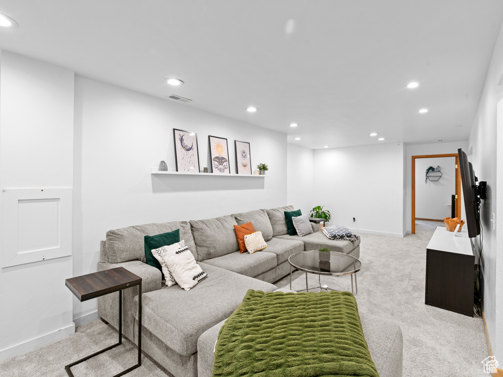 Living area with recessed lighting and light colored carpet