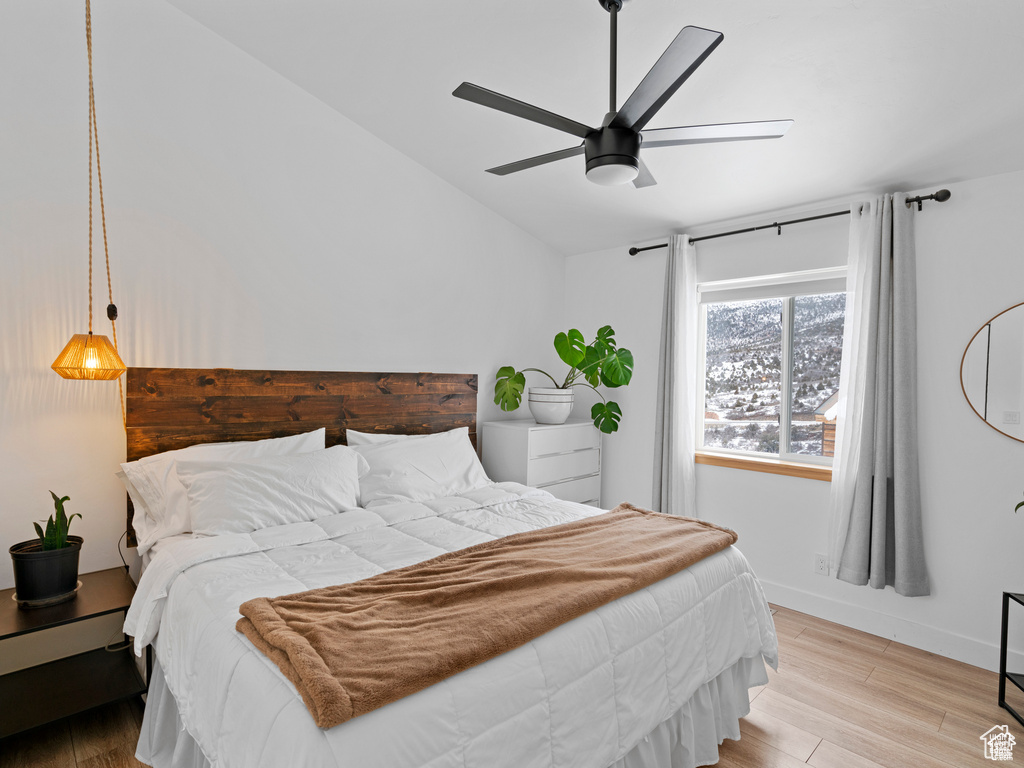 Bedroom with light wood-style floors, lofted ceiling, and ceiling fan