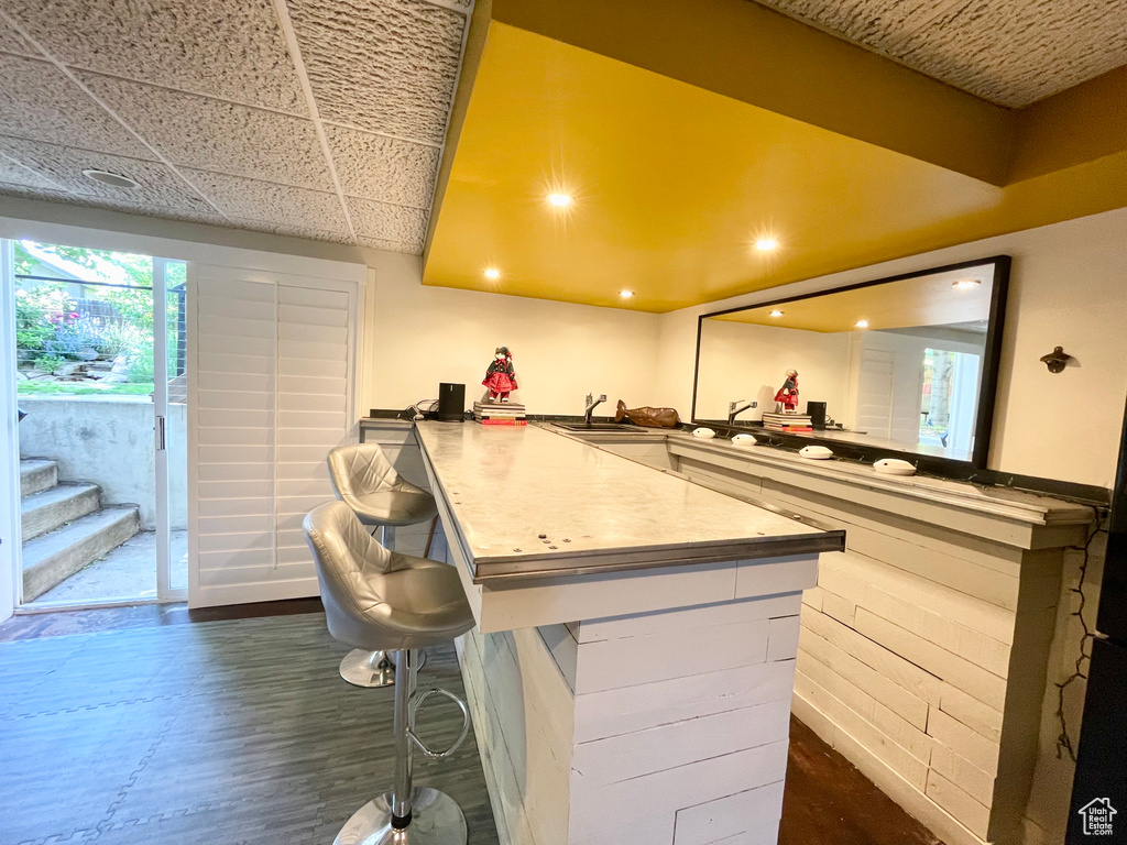 Kitchen featuring a peninsula, a kitchen breakfast bar, recessed lighting, and dark wood-style floors
