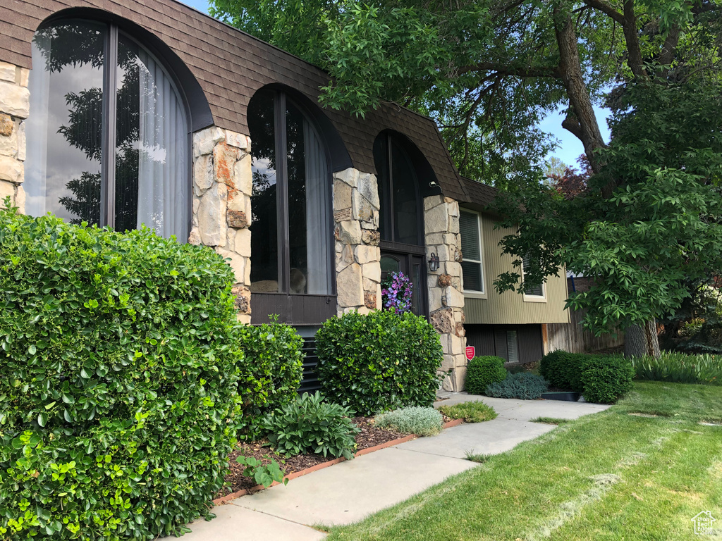 Property entrance with stone siding and a yard