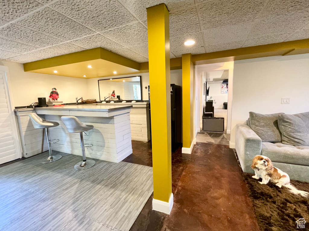 Bar area featuring a drop ceiling and baseboards