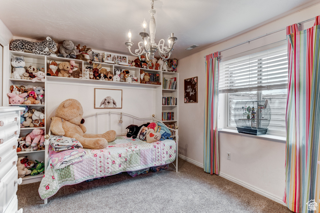 Bedroom with a chandelier and carpet