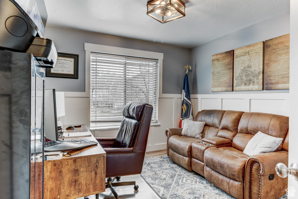 Home office featuring light wood finished floors and wainscoting