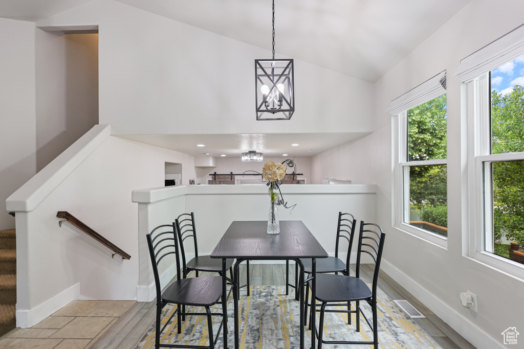 Dining area with a chandelier, baseboards, and high vaulted ceiling