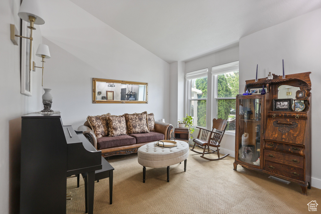 Carpeted living area featuring vaulted ceiling