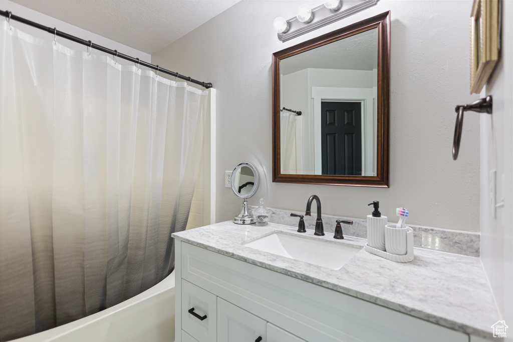 Full bathroom with vanity and shower / bath combo with shower curtain