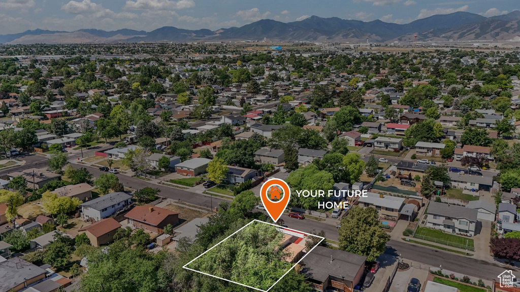Aerial view of residential area with a mountainous background and property parcel outlined