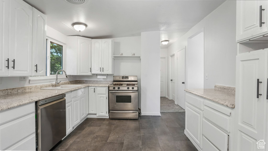 Kitchen featuring appliances with stainless steel finishes and white cabinetry