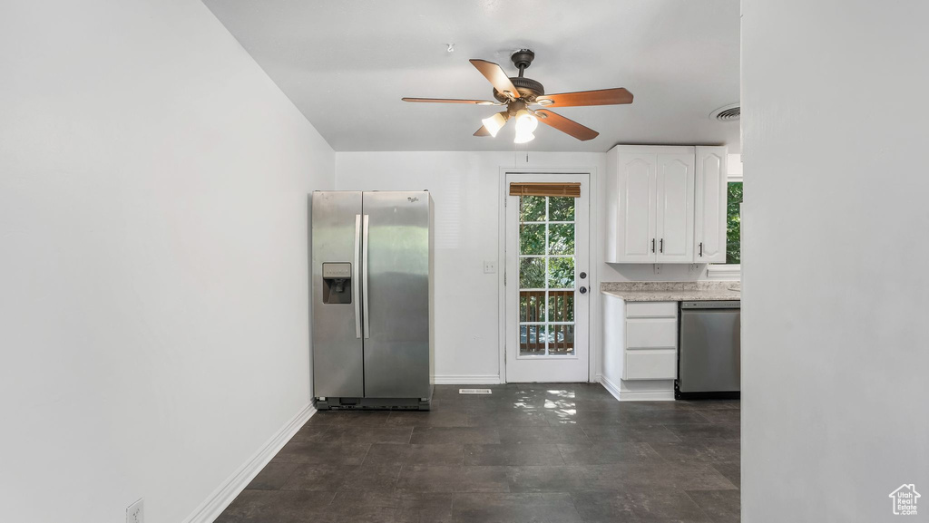 Kitchen with appliances with stainless steel finishes, a ceiling fan, light countertops, and white cabinets