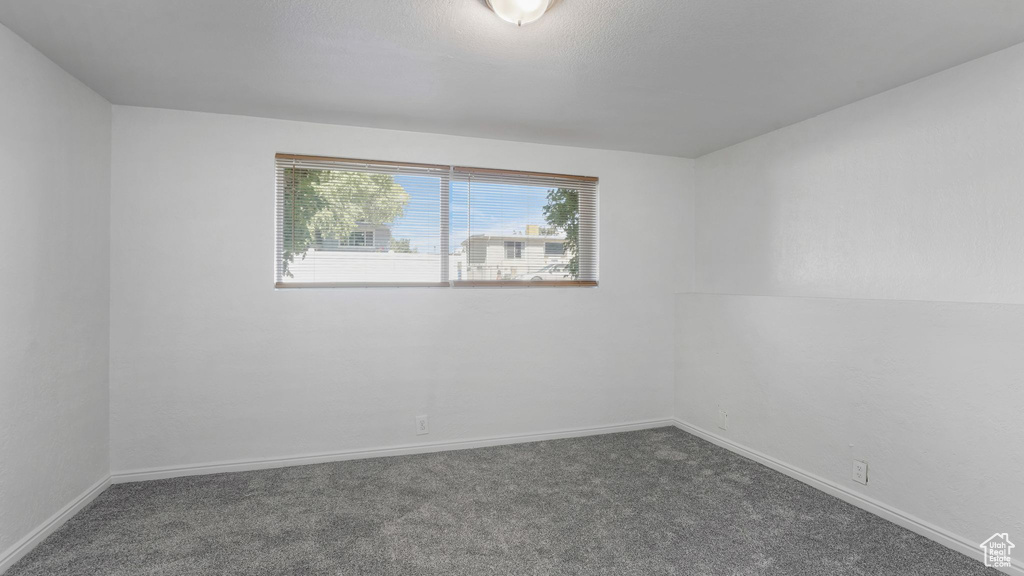 Unfurnished room with dark colored carpet