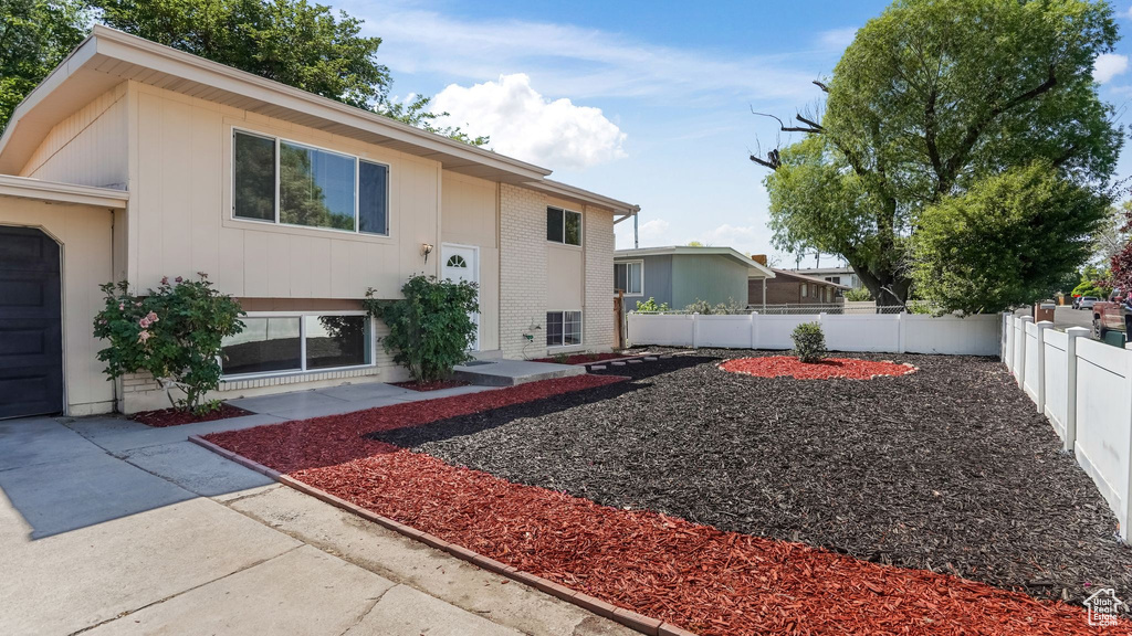 View of front of home featuring a fenced backyard, brick siding, and a patio