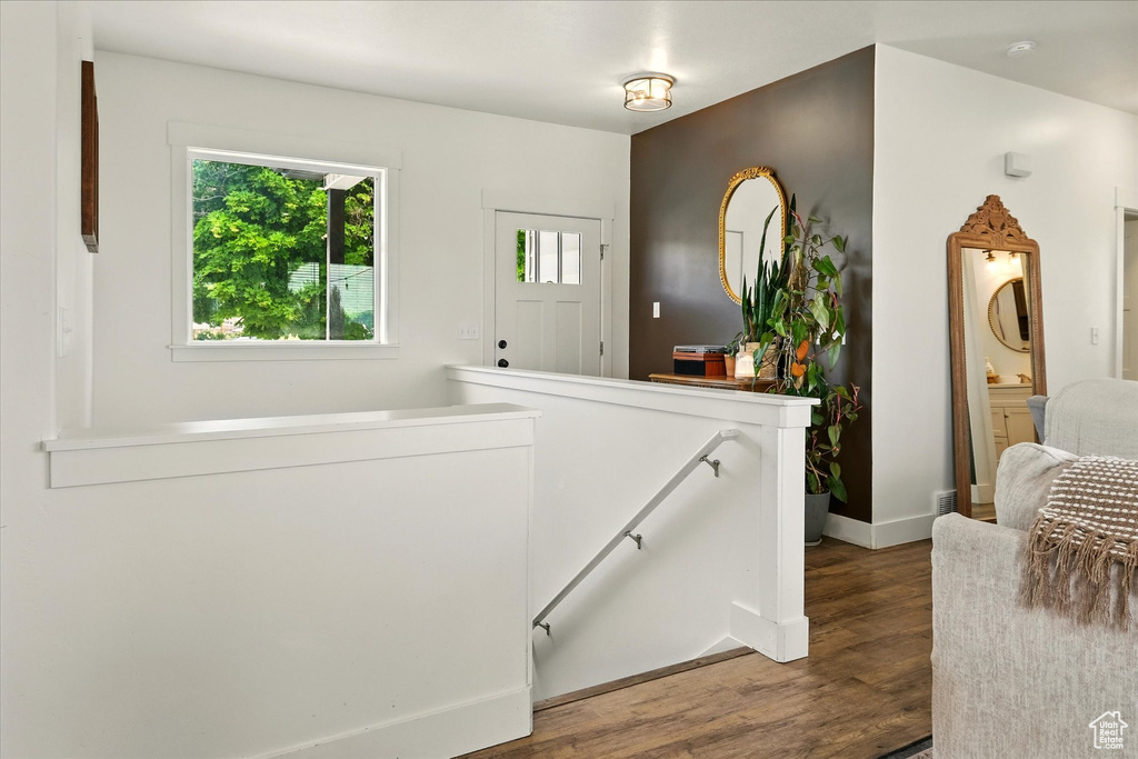 Hall with an upstairs landing and dark wood-style flooring