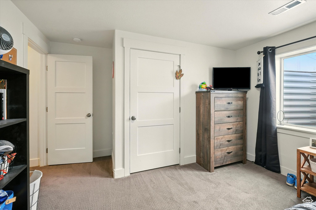 Bedroom featuring light colored carpet