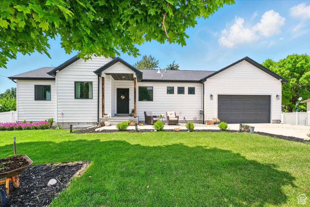 View of front of property with a garage, concrete driveway, an outdoor living space, and a shingled roof
