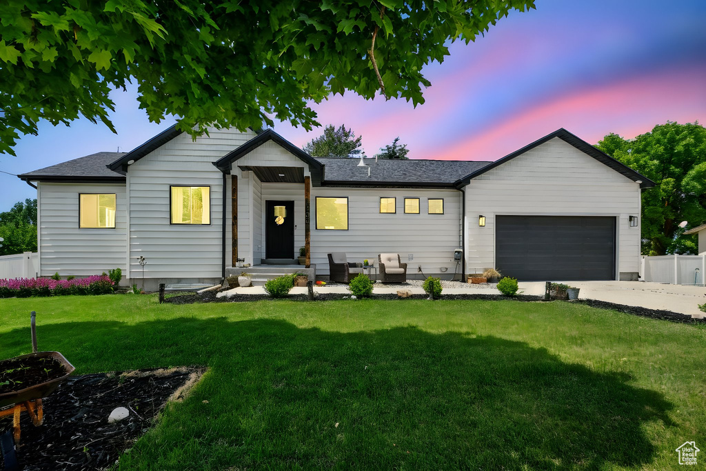 View of front facade with a garage, driveway, and a shingled roof