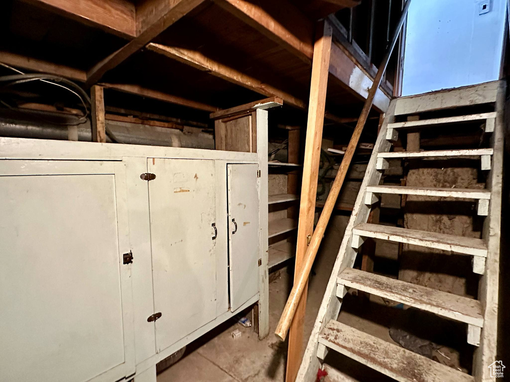 Stairs featuring unfinished concrete floors