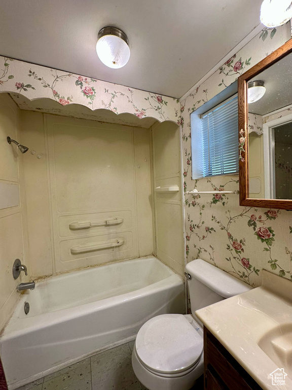 Bathroom featuring wallpapered walls, shower / bath combination, and vanity