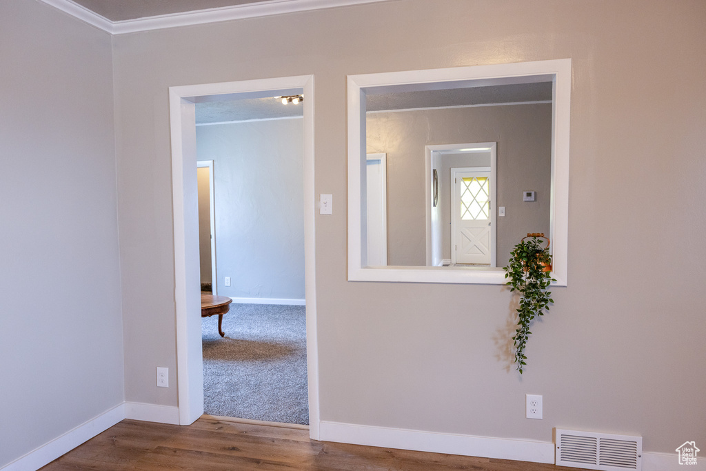Unfurnished room featuring ornamental molding and wood finished floors
