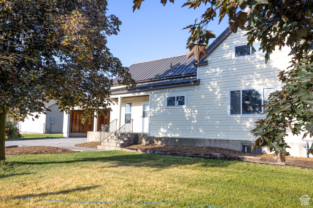 View of front of property featuring a front yard, a metal roof, and entry steps