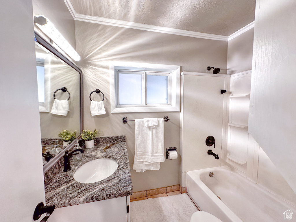 Full bathroom with crown molding, vanity, shower / bathtub combination, and tile patterned floors