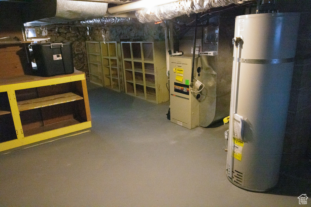 Unfinished below grade area featuring secured water heater and heating unit