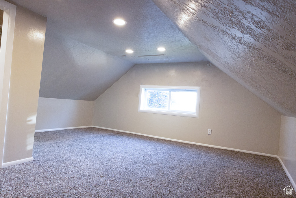 Additional living space with carpet floors, recessed lighting, and lofted ceiling