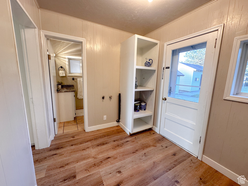 Foyer entrance with light wood-style flooring and ornamental molding