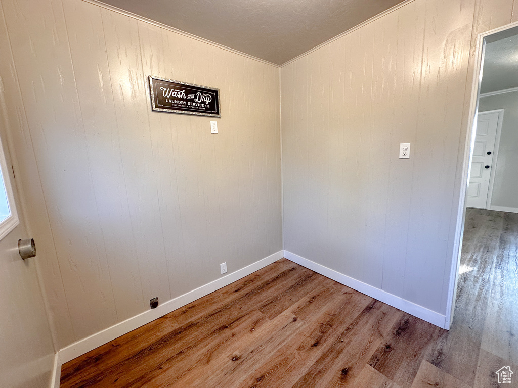 Spare room with wood finished floors and crown molding