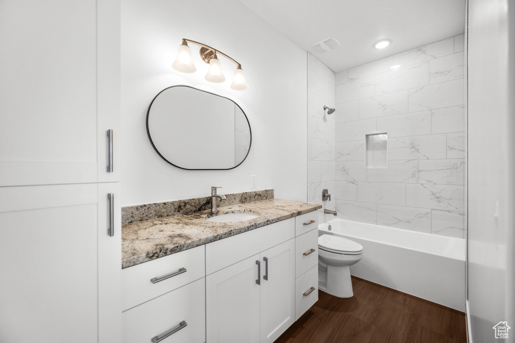 Bathroom with vanity, wood finished floors, washtub / shower combination, and recessed lighting