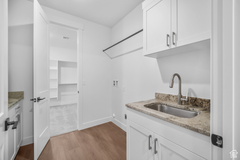 Washroom featuring hookup for a washing machine, dark wood finished floors, cabinet space, and wet bar