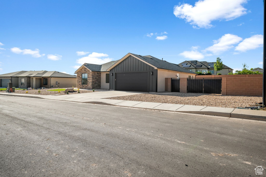 View of front of property with a residential view, an attached garage, driveway, and board and batten siding