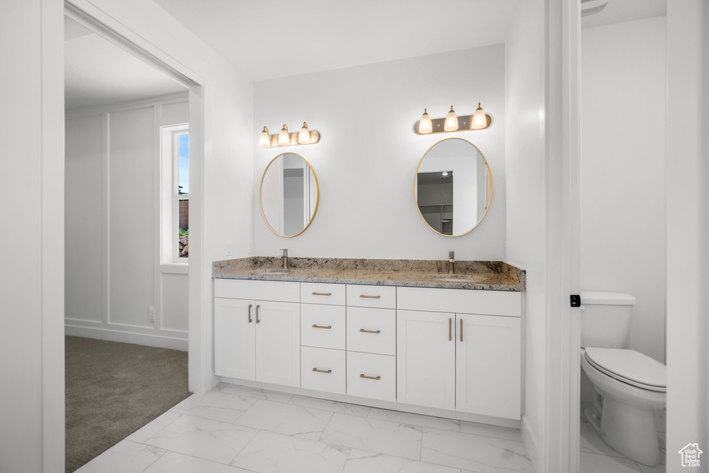 Bathroom with marble look tile flooring and double vanity