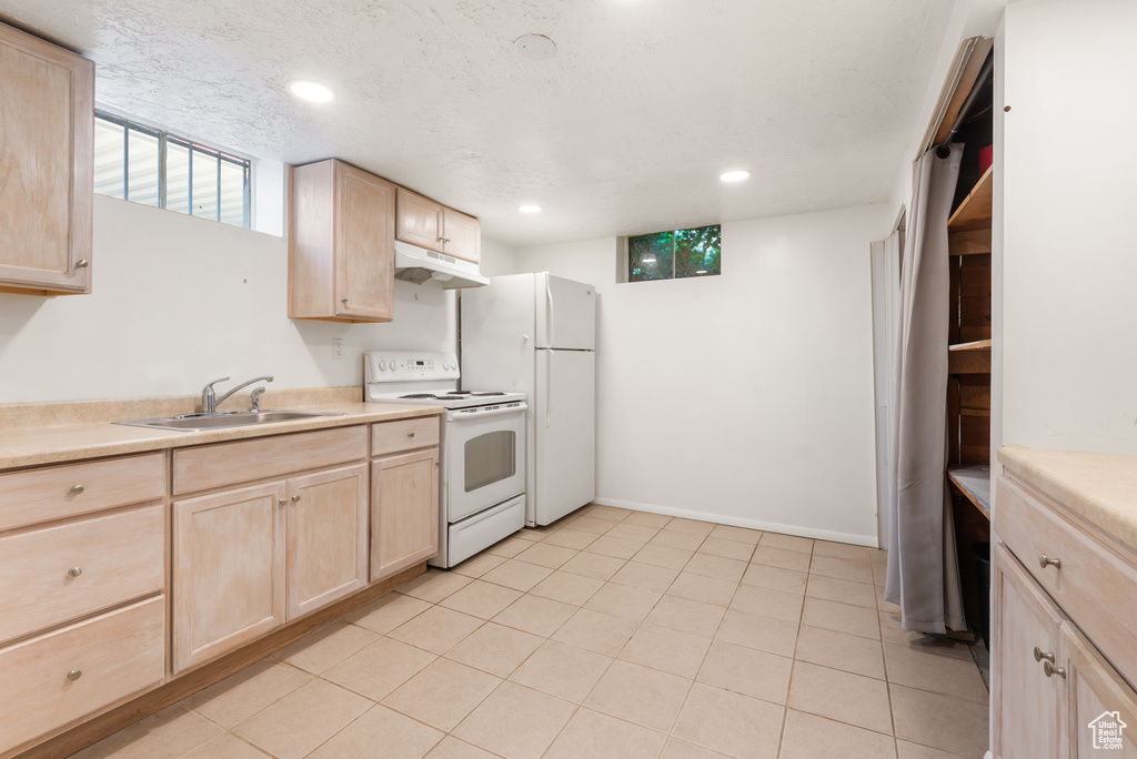 Kitchen with light brown cabinetry, white appliances, under cabinet range hood, light countertops, and recessed lighting