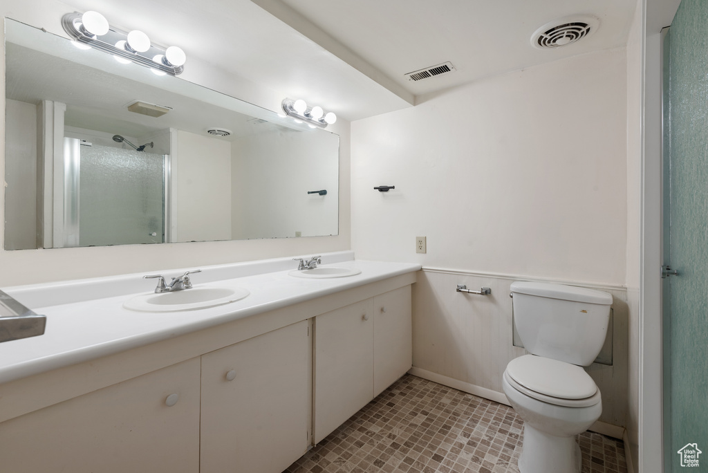 Bathroom featuring double vanity, an enclosed shower, and tile patterned floors