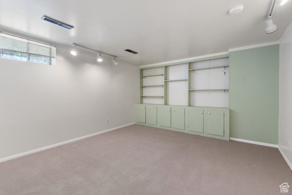 Empty room with rail lighting, light carpet, and a smoke detector