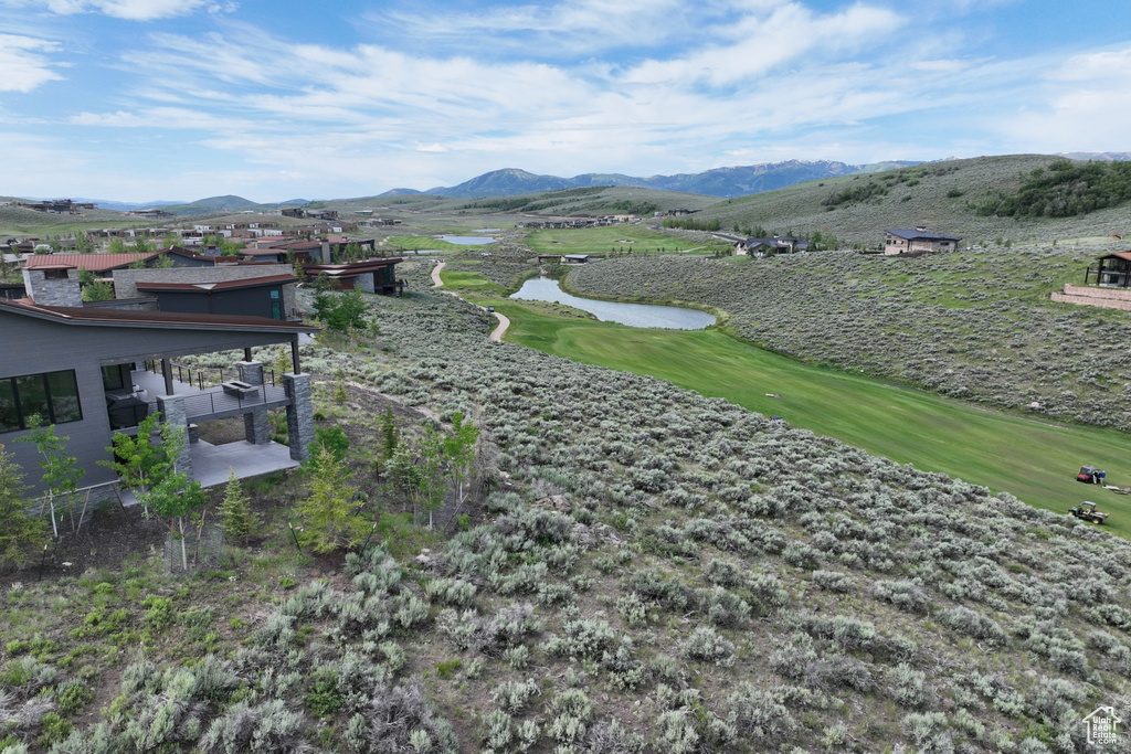 View of mountain background featuring a nearby body of water and a golf club