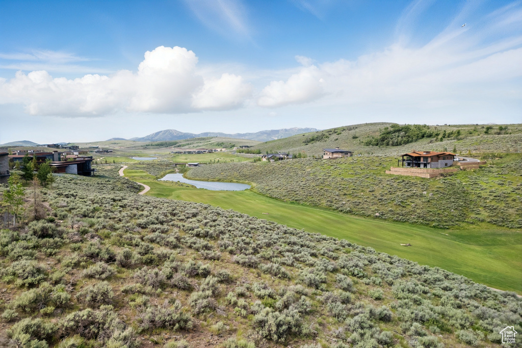 View of mountain backdrop with a large body of water and a golf course