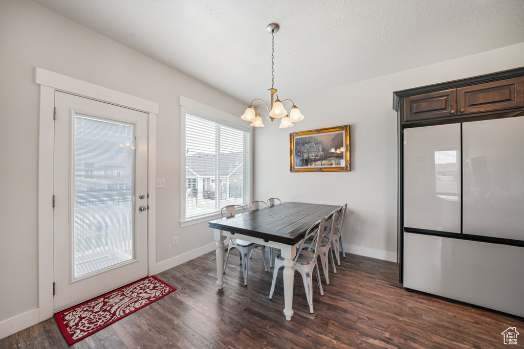Dining space featuring a chandelier and dark wood finished floors