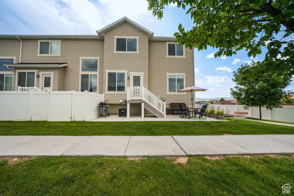 Rear view of house featuring stucco siding and a patio area