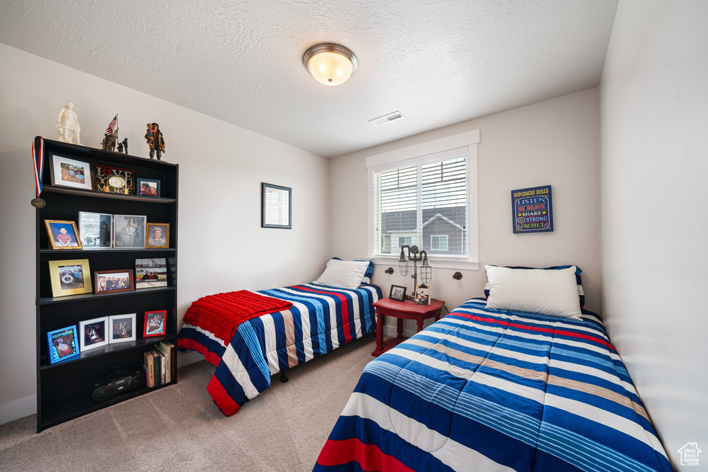 Bedroom with carpet flooring and a textured ceiling