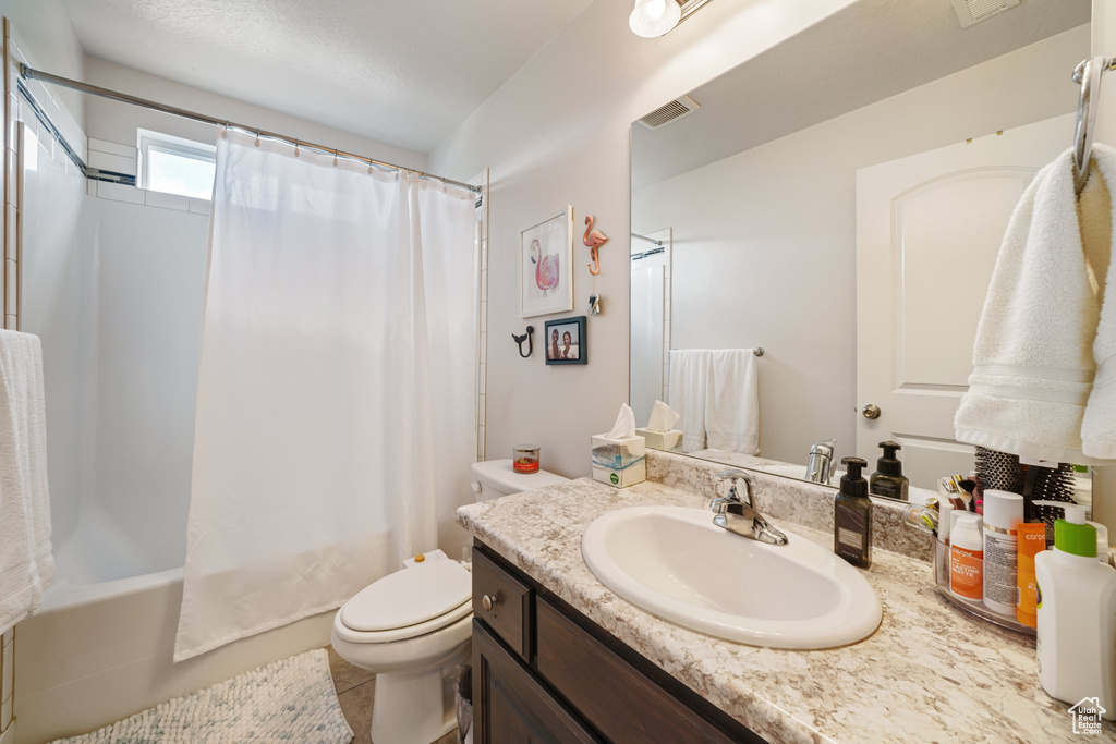 Bathroom featuring vanity and shower / bath combo with shower curtain