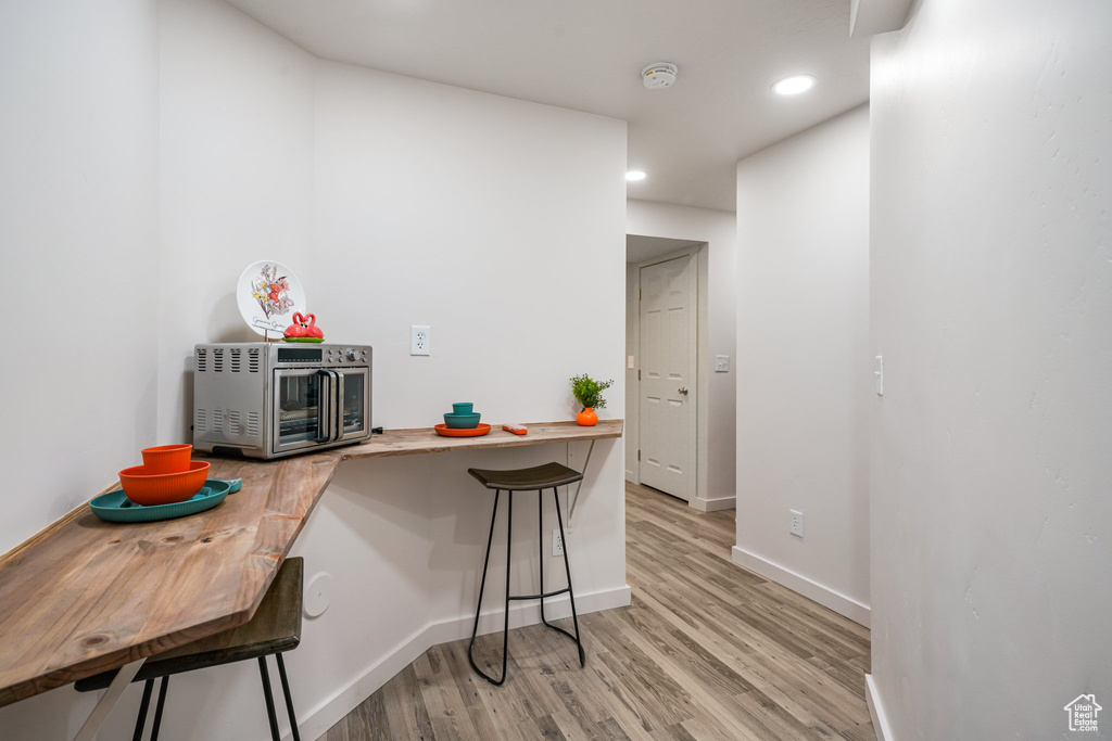 Kitchen with a kitchen breakfast bar, light wood-style flooring, and recessed lighting